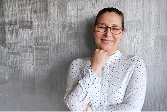 Porträt von Juliane Fröhlich, lächelnd mit Brille